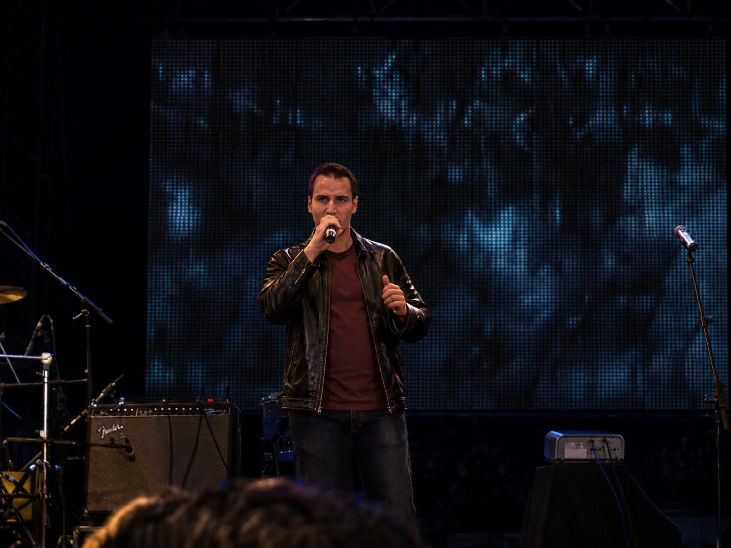 Daniel Domínguez presentando en un escenario con micrófono